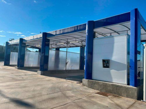 Estructura azul para boxes de lavado instalada en una zona exterior de un centro de lavado